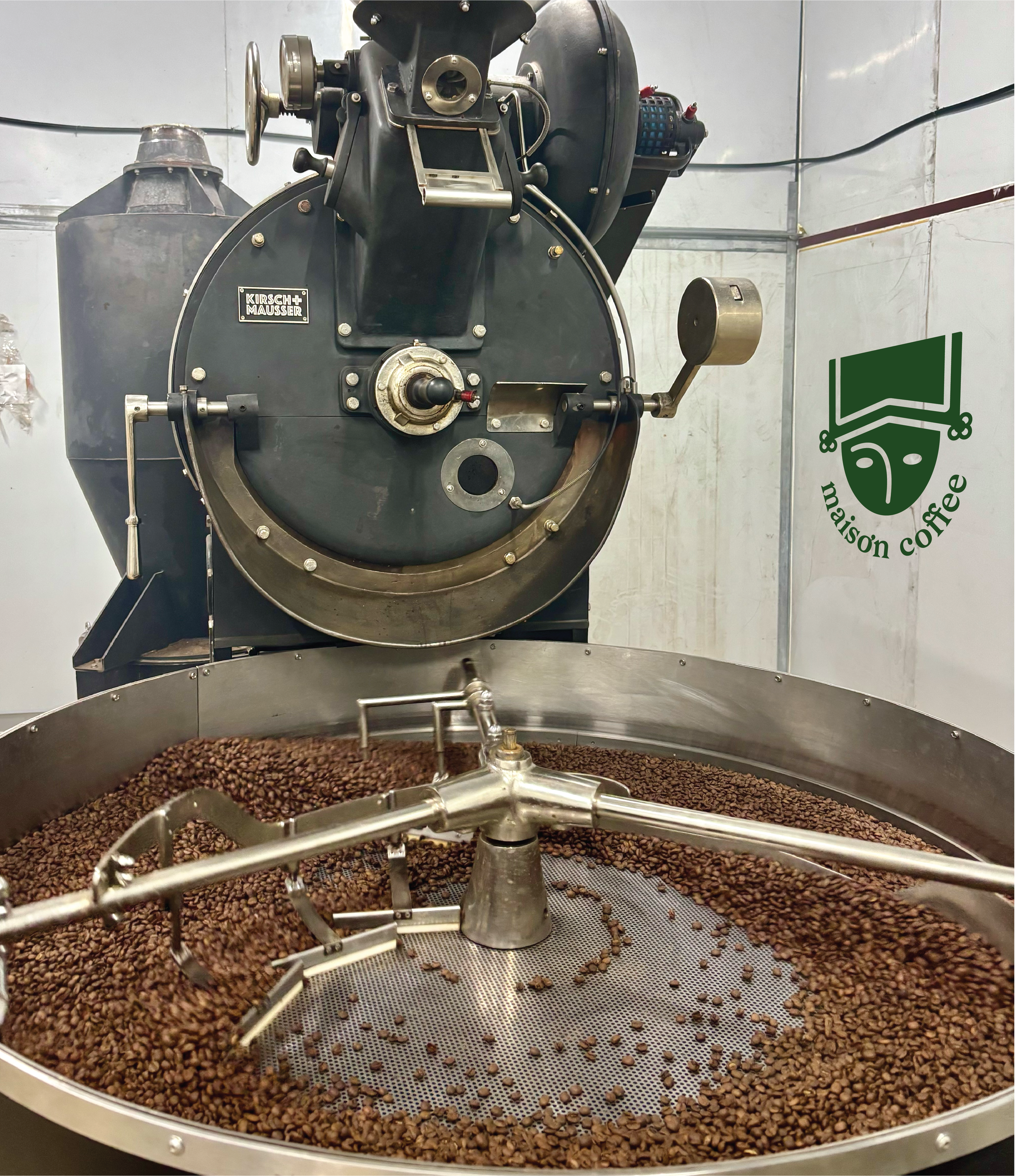 Coffee beans tumbling in the roasting drum and cooling tray at Maison Coffee's roastery